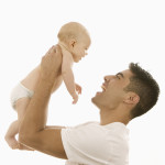 Man Holding Up an Infant